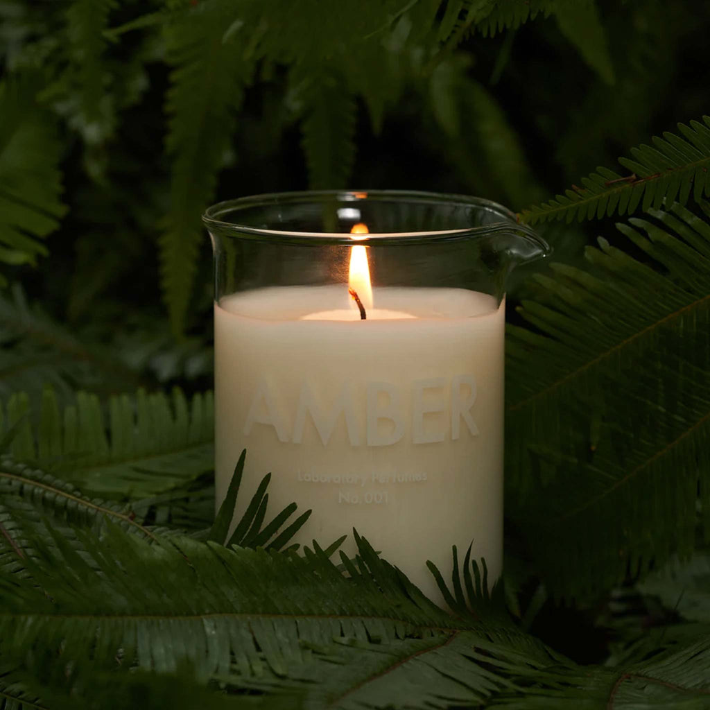 A glass beaker holds a candle in Laboratory's iconic, warm Amber scent. Made in the UK with cruelty free ingredients.