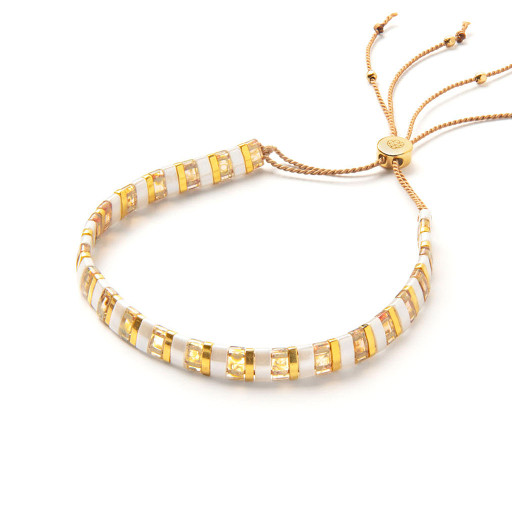 Bestselling Gold Terrazzo Slider Bracelet. Adjustable silk beaded bracelet. Perfect for layering and stacking, a minimal beaded bracelet with contrasting white and gold beads. Designed and handcrafted in the UK by Wanderlust Life. Trending beaded jewellery.