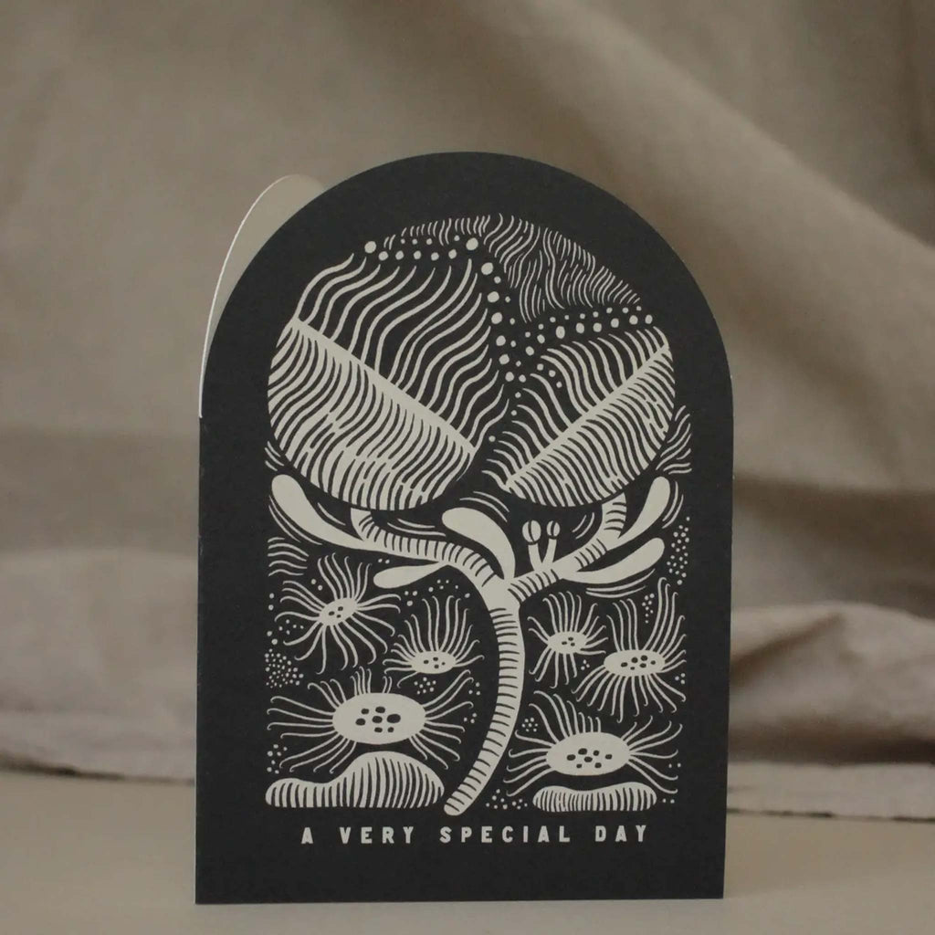 Arched shaped black card with a botanical  illustration and the message 'a very special day'. Designed by Lauren Marina.
