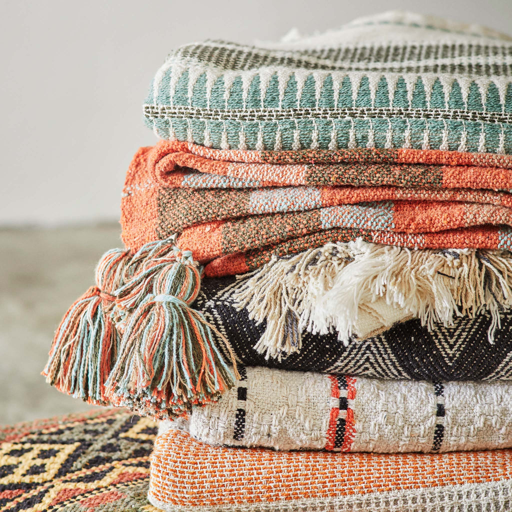 Colourful cotton throws with geometric patterns.