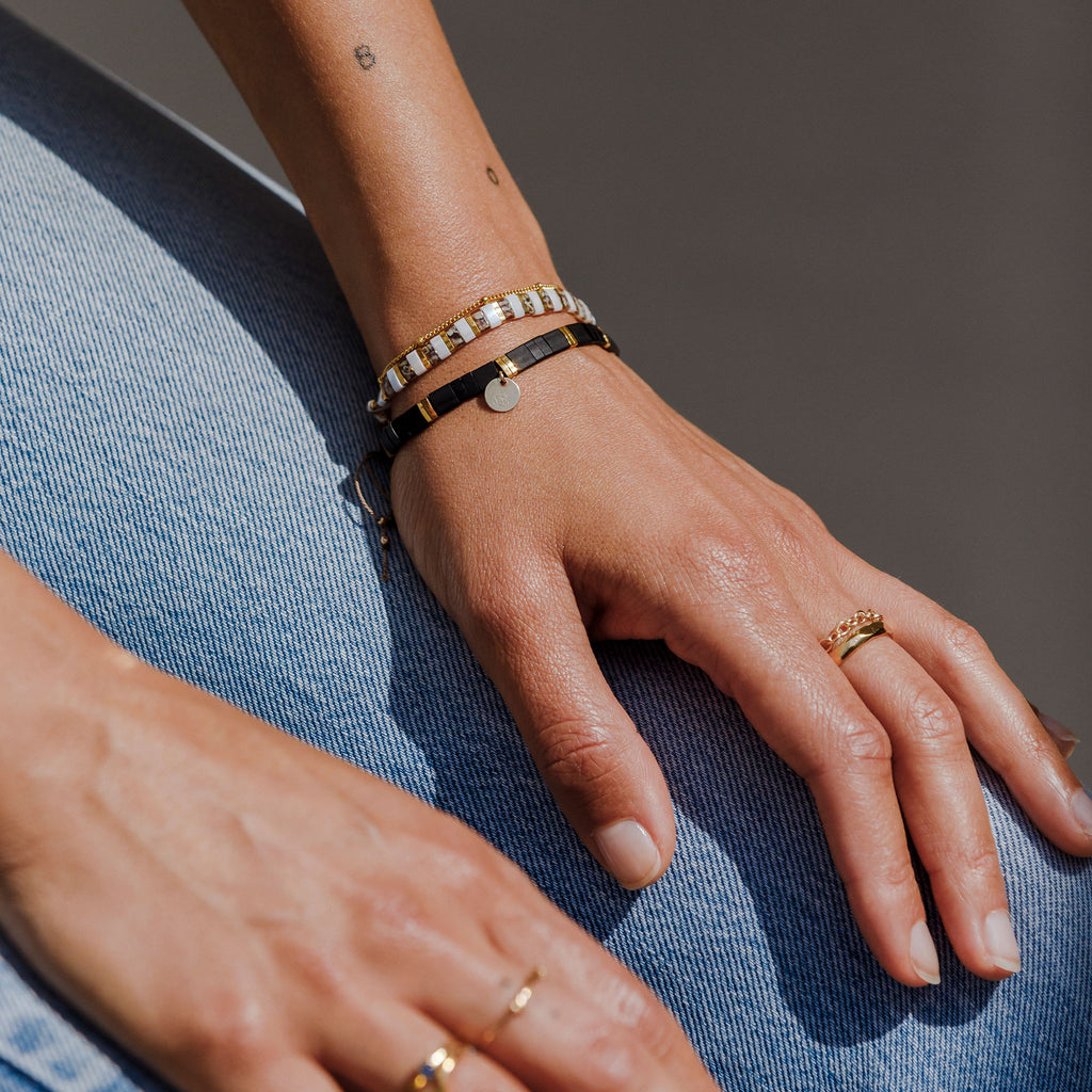 The Moonlight Layering Bracelet features black and gold alternating beads. Worn with the bestselling Terrazzo slider bracelet.