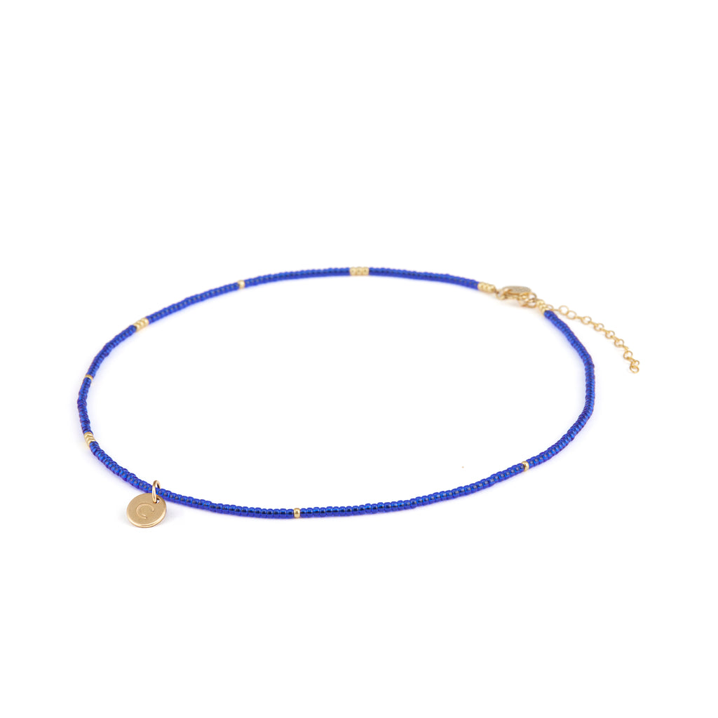 Personalised with a gold-fill initial charm, hand-stamped with the letter C. The Morocco Blue Beaded Necklace features cobalt blue and gold seed beads, and a length of gold-fill chain making this choker style necklace an adjustable length.