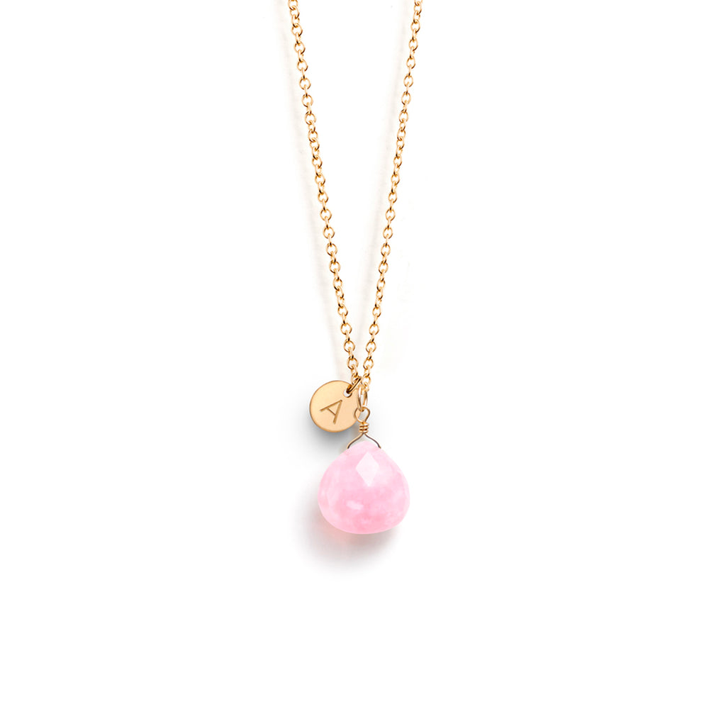 A birthstone necklace for October birthdays featuring a faceted pink opal gemstone. This birthstone necklace is personalised with a circular gold disc, hand-stamped with an A initial.