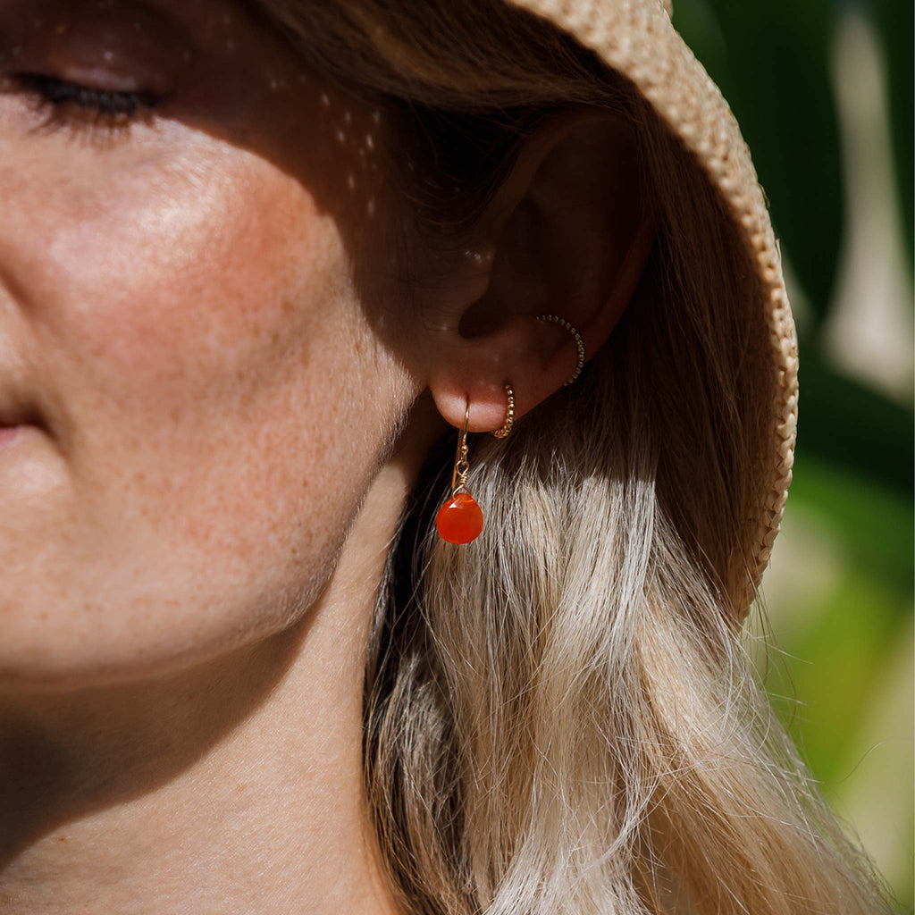 Our signature Isla Drop Earrings featuring bright orange carnelian gemstones. Styled in a minimal ear stack with the solstice hoop earrings and solstice ear cuff.