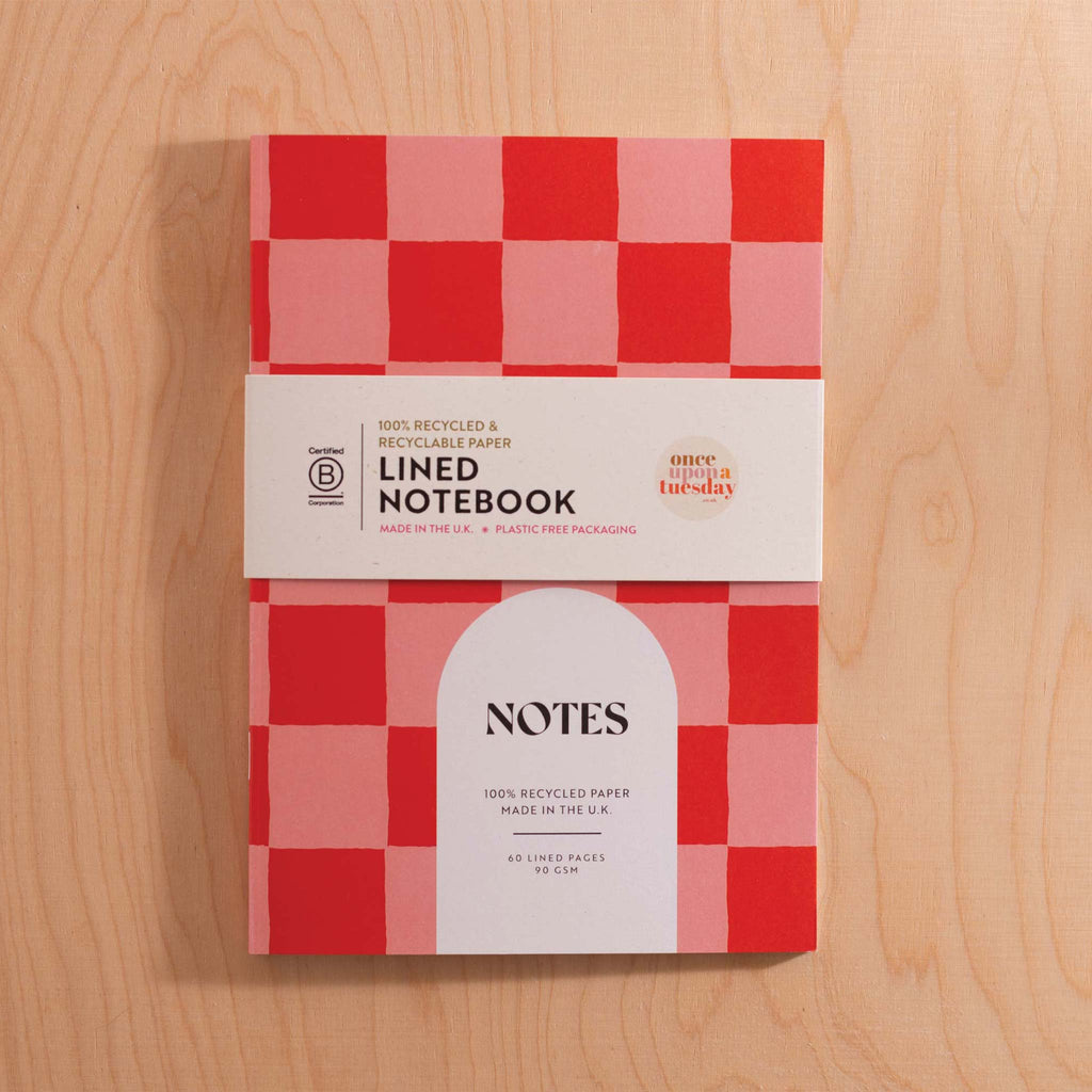 A5 checkered cherry red and pink notebook, featuring 60 lined pages with a little palm tree detail at the bottom of every page.