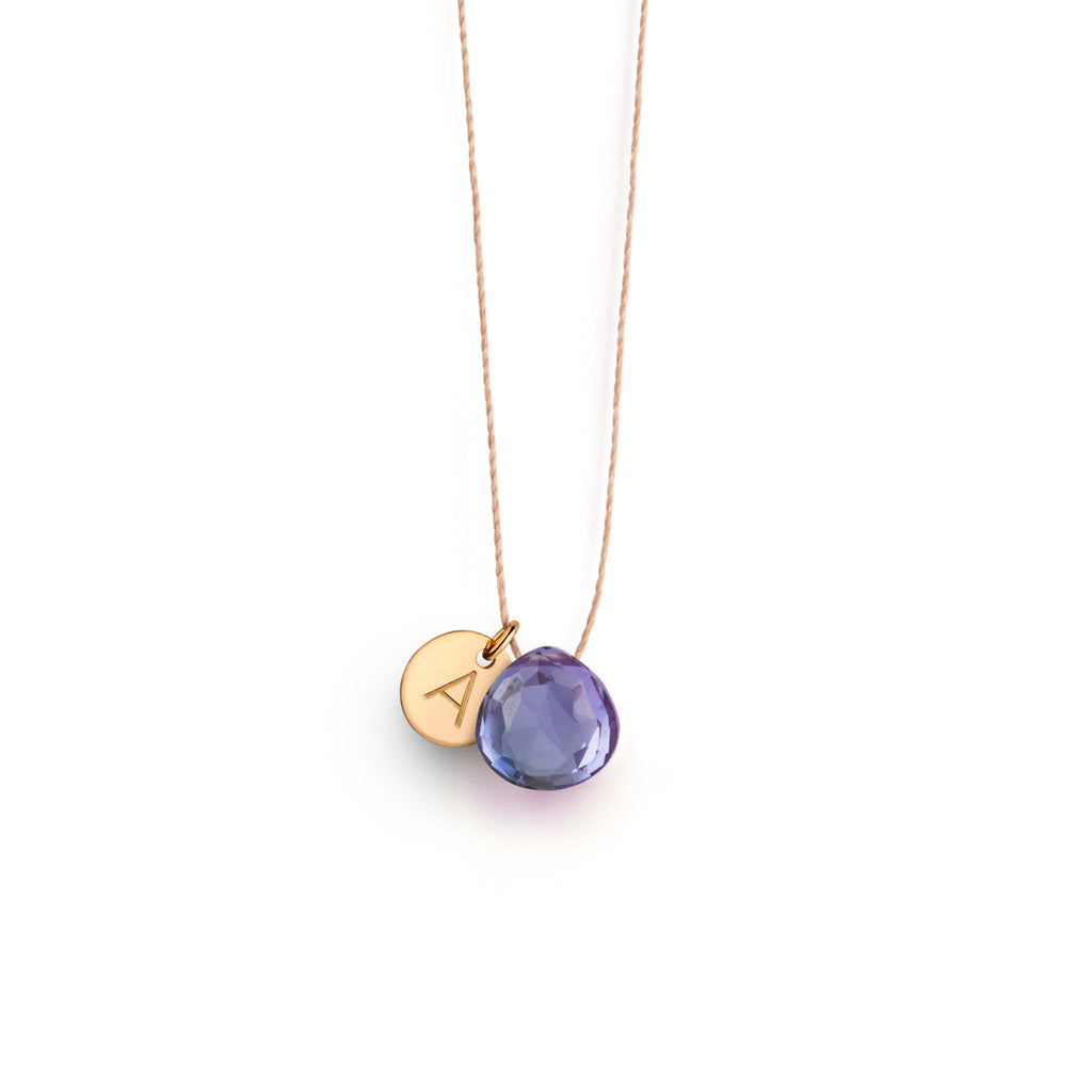 The Alexandrite Quartz Fine Cord Necklace is a blue and purple gemstone, strung on a minimal fine cord. This gemstone necklace is personalised with an initial tag. Shop affordable and personalised gemstone jewellery.