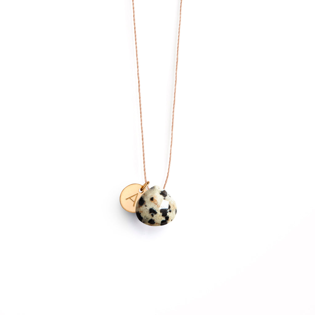 A dalmation jasper gemstone is strung on a fine cord necklace, and personalised with a monogram initial tag. Shop modern and minimal, personalised jewellery online at Wanderlust Life. Affordable, everyday jewellery designed and handcrafted in the UK.