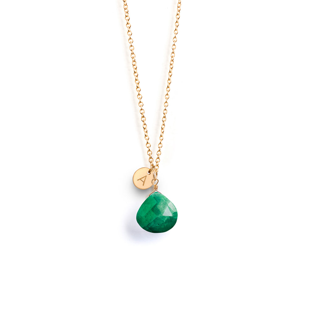 A May Birthstone necklace features an emerald gemstone in our signature faceted shape. This birthstone necklace is personalised with a circular gold charm, hand-stamped with an A initial.
