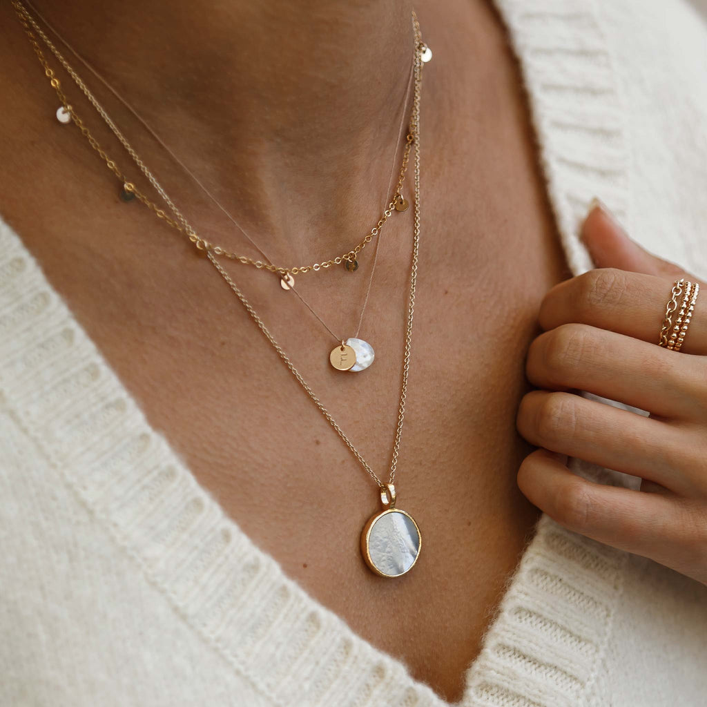 Personalised with a monogram tag, the mother of pearl fine cord is one of our bestselling, signature necklaces. Create a personalised initial necklace.