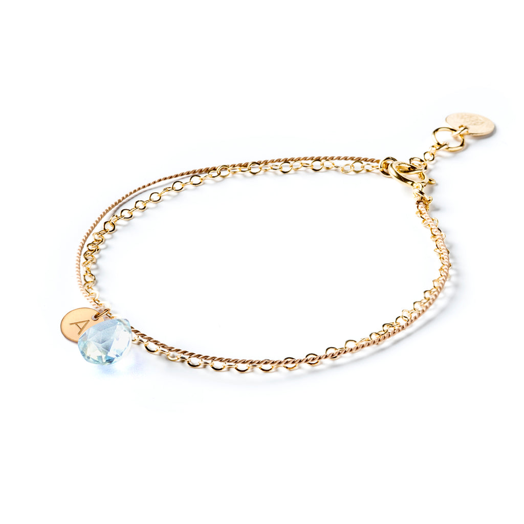 Personalised Topaz November Birthstone Gold and Silk Bracelet. Choose your initial and we hand-stamp your initial tag, made to order. Shop meaningful and personalised birthstone jewellery.