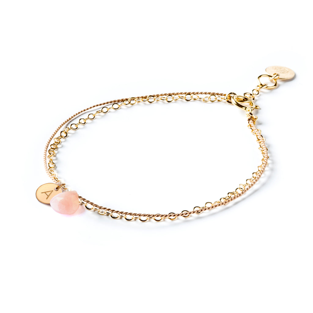 The October Birthstone pink opal Gold and Silk Bracelet, personalised with an initial tag. Choose your initial and our team will hand-stamp your initial tag, made to order. Shop meaningful and personalised birthstone jewellery gifts at Wanderlust Life.