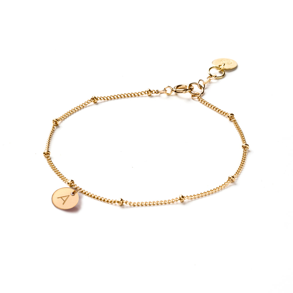 The Satellite Chain features gold beads at regular intervals; personalised with a hand-stamped initial tag. Shop personalised monogram jewellery at Wanderlust Life.