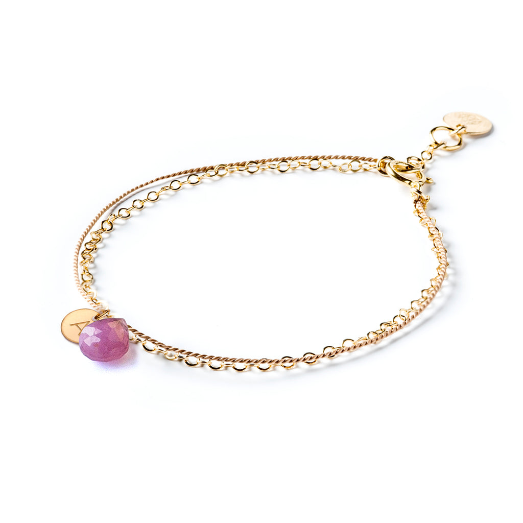 September Birthstone Bracelet with a pink sapphire gemstone, paired with a personalised initial tag. Choose your initial and our jewellery maker’s personalise your birthstone bracelet. Shop minimal, modern and meaningful personalised birthstone jewellery.
