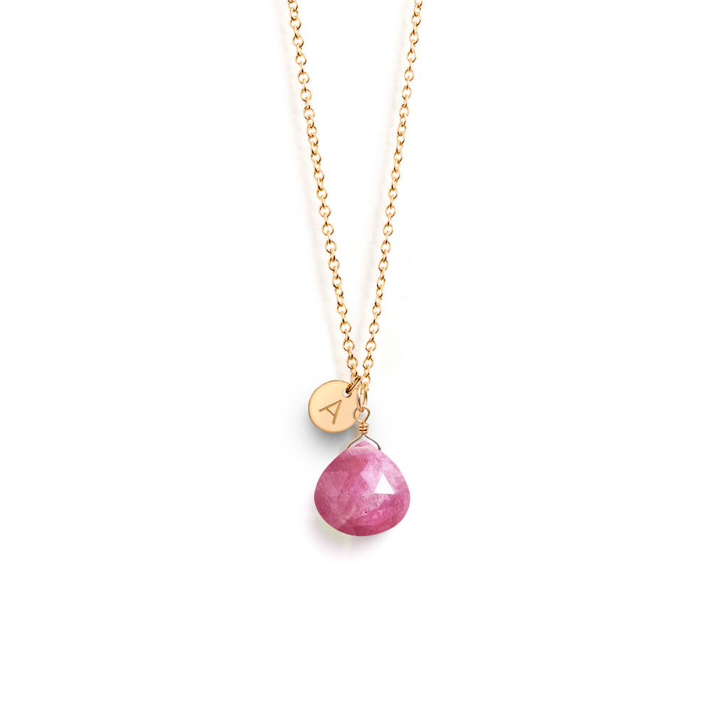 The September Sapphire Birthstone Pendant Necklace features a pink sapphire in our signature faceted shape. This necklace is personalised with a circular gold charm, hand-stamped with an A initial.