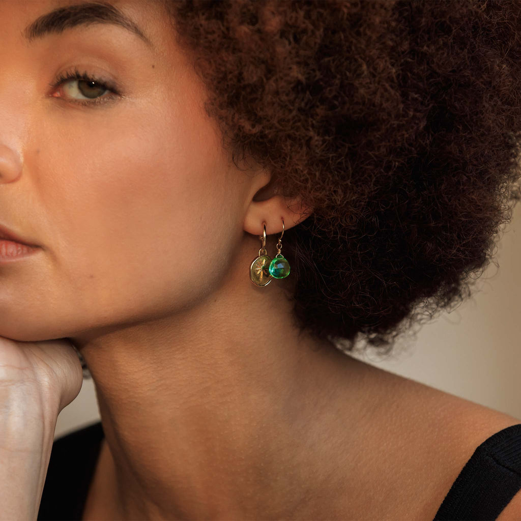 Model wears seafoam green quartz Isla Drop Earrings, worn in the second piercing, styled with gold drop hoop earrings. These colourful gemstone earrings can be worn solo or styled with other earrings in an ear stack.