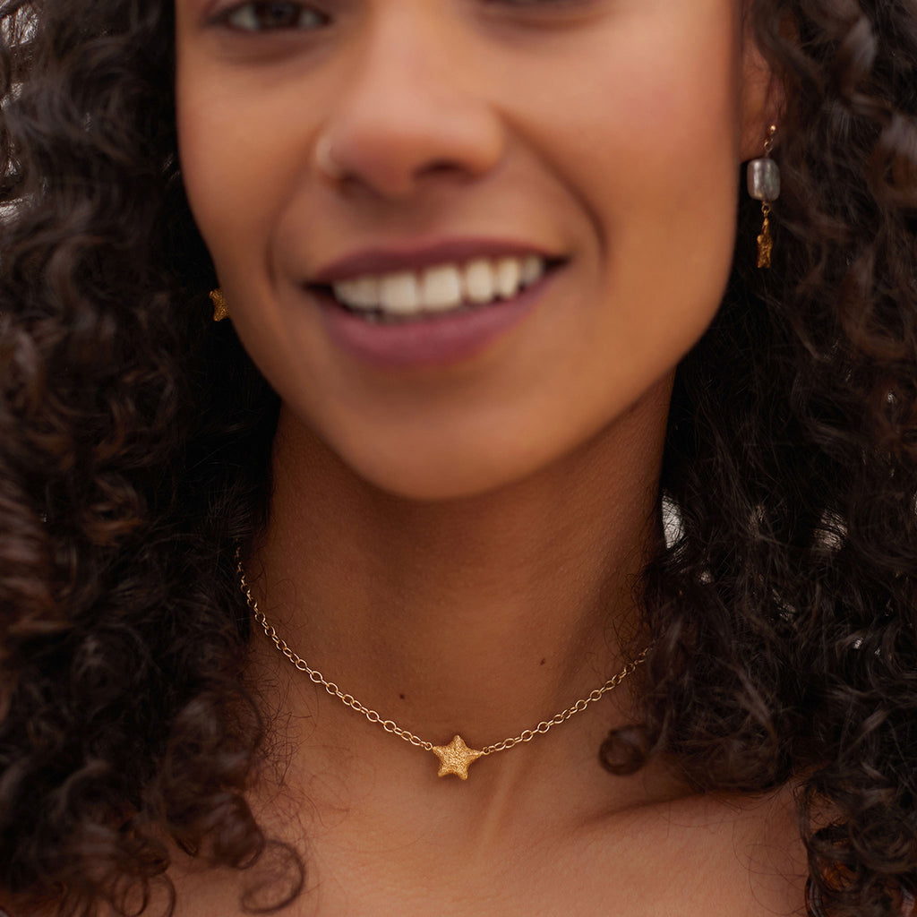 Wanderlust Life Star Wish Choker Necklace. A textured gold star fish sits symmetrically in the centre of a gold statement chain. Short in length, this piece is perfect for layering into your necklace stack, or wearing solo as a statement piece this summer. Shop the new Sea Dreams collection online at Wanderlust Life.