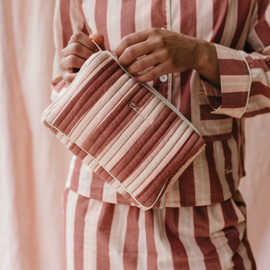 A quilted wash bag a with red, pink and cream striped pattern