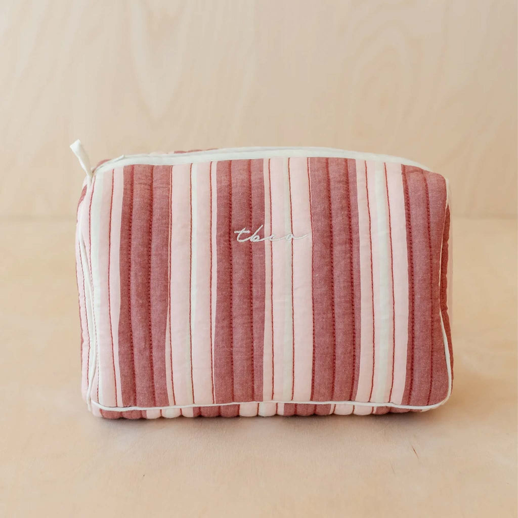 A quilted wash bag a with red, pink and cream striped pattern