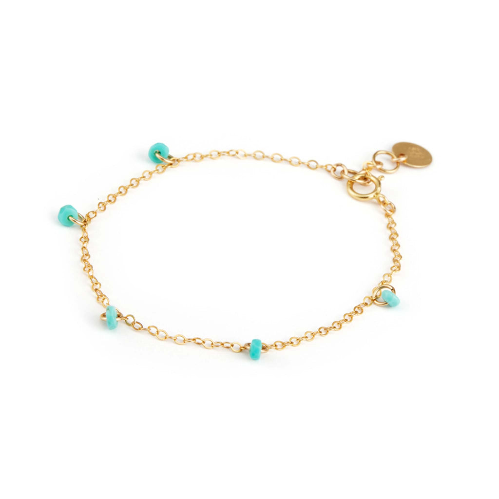 Faceted turquoise rondels are fastened at regular intervals to a minimalist gold chain bracelet.