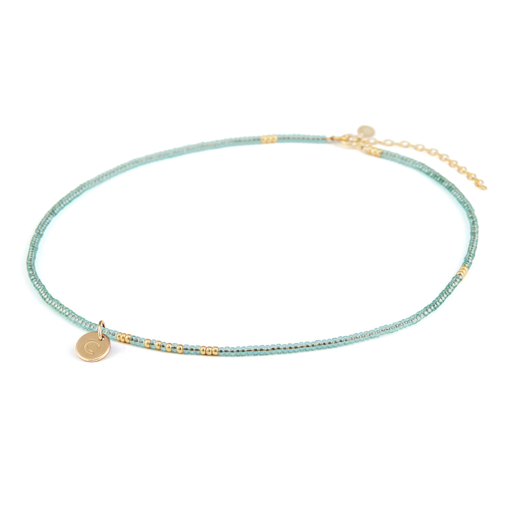 Personalised with a gold fill initial charm, hand-stamped with a C initial. The necklace is a light blue and gold beaded choker style necklace. Perfect for summer styling and gifting.