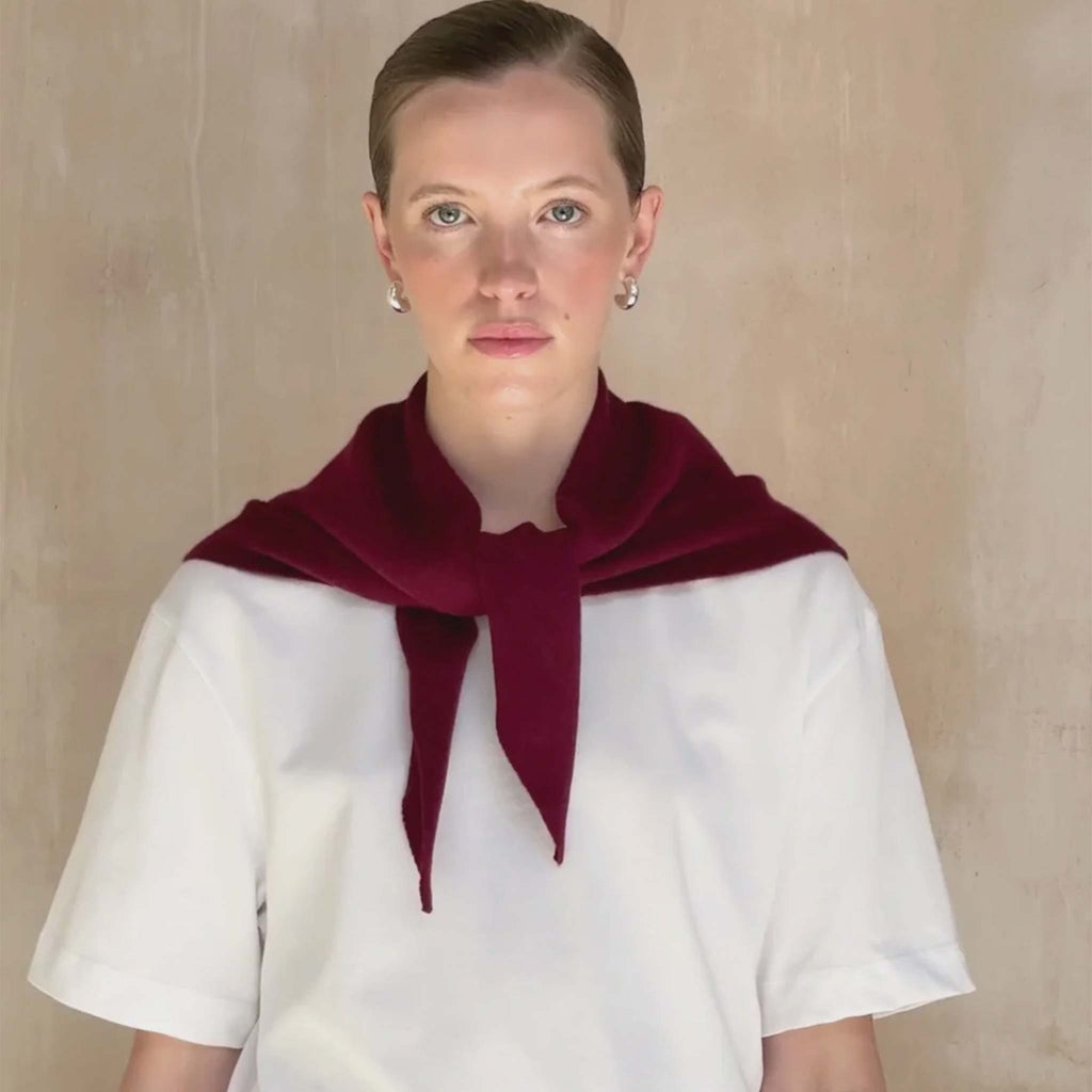 A burgundy triangle scarf knitted from 100% merino wool.