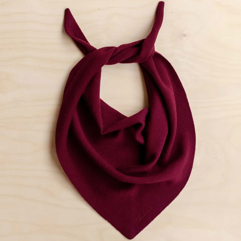 A burgundy triangle scarf knitted from 100% merino wool.