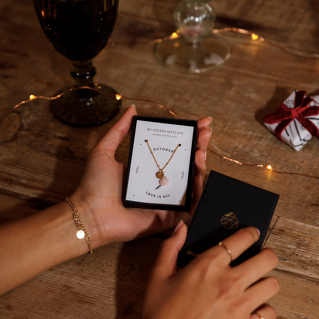 Opal October Pendant Necklace on a 14k Satellite chain with a hand stamped initial tag in a gift box.