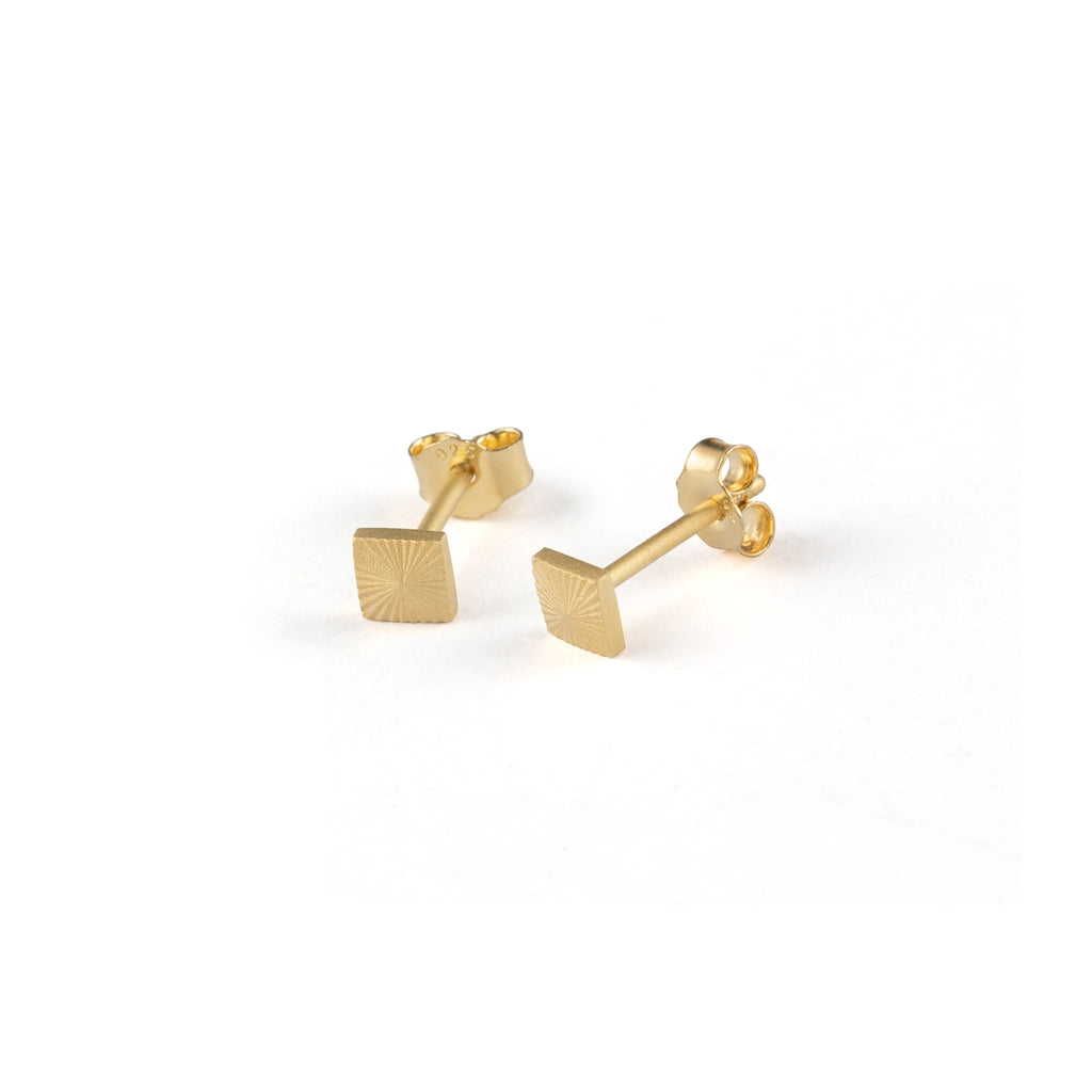 Gold vermeil studs in a geometric shape feature etched lines.