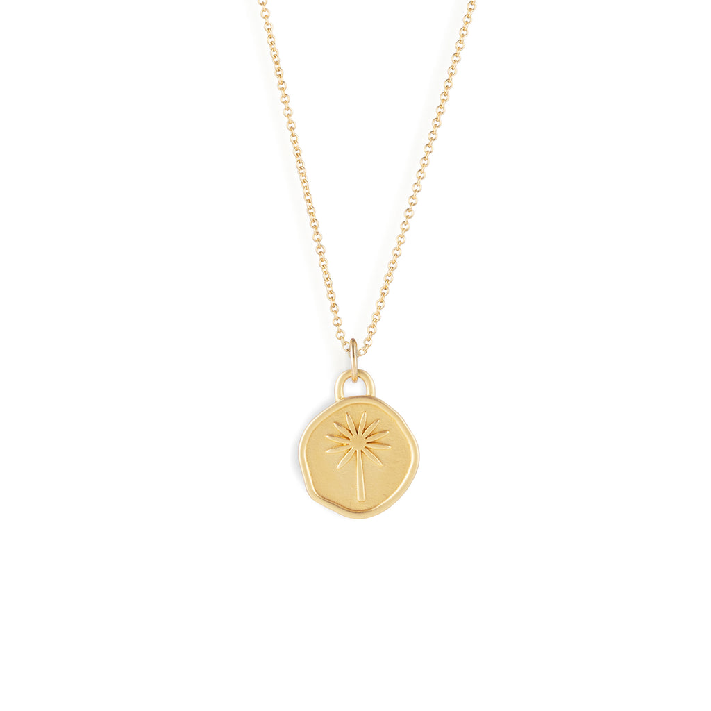 An organically shaped pendant features a palm tree design, symbolising the earth elemental sign.