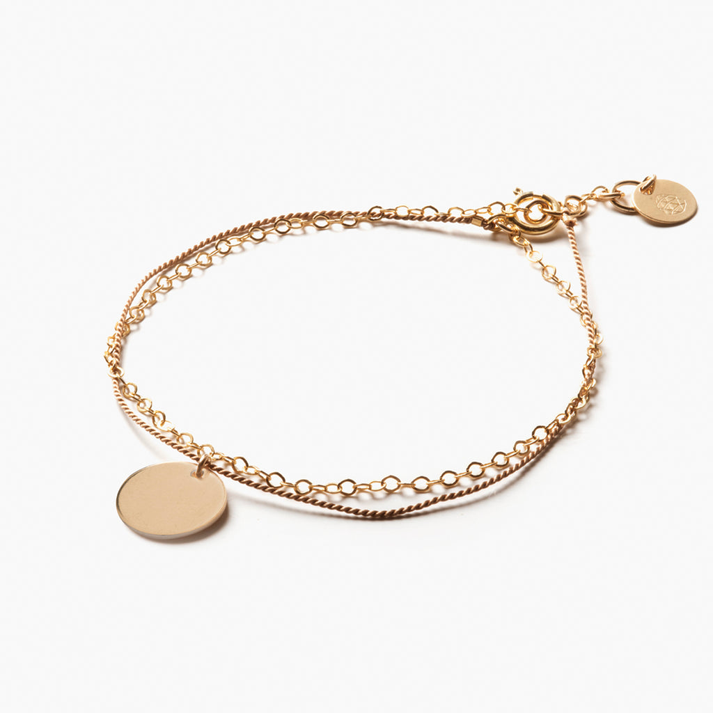 A Gold & Silk bracelet with engraved 11mm disc. The perfect personalised gift for jewellery lovers.