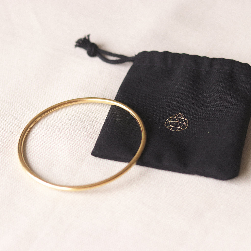 Silke Gold Bangle. 14 carat gold plated hollowed silver bangle. Available in 2 sizes - 64mm or 66mm. Proudly designed in Devon and crafted by our Wanderlust Life global artisan partners. Now available with a Wanderlust Life Gold foiled branded linen bangle pouch.