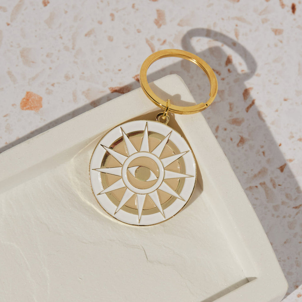Eye-catching cream and gold Mati enamel key chain by Cai & Jo. Shop the Cai & Jo collection at Wanderlust Life. 